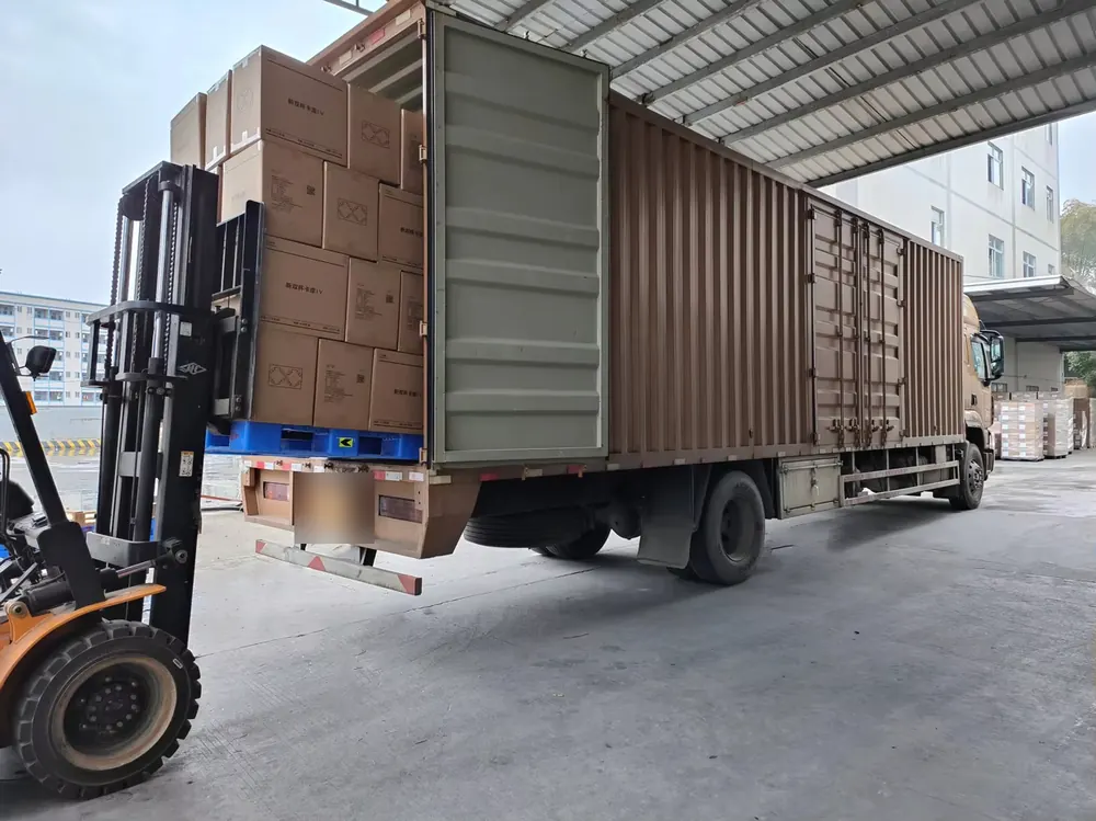 Forklift loading palletised cartons of paper packaging onto a truck